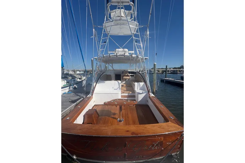Slide: The Image of 1991 Garlington 44 Express yacht docked, showcasing elegant wooden deck and tower. - 6