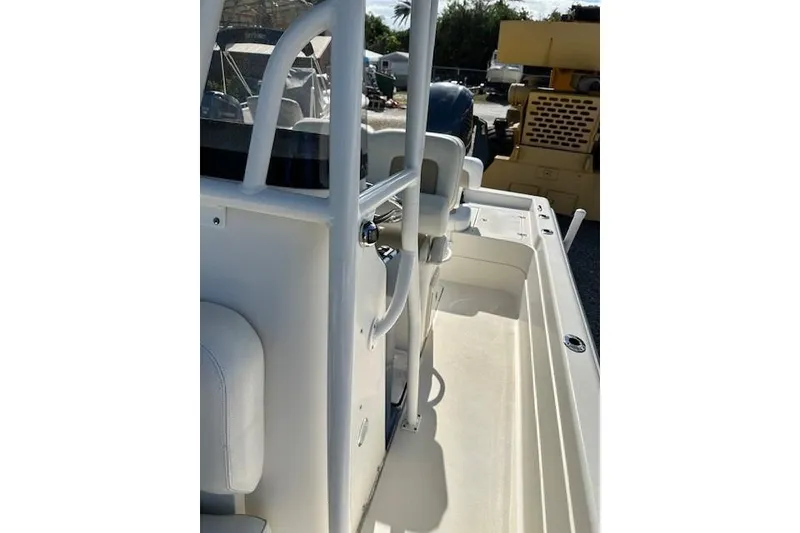 Slide: The Image of 2014 ShearWater 25 LTD boat interior with seating and railing, parked outdoors. - 18