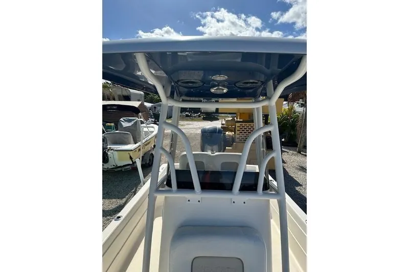 Slide: The Image of 2014 ShearWater 25 LTD boat interior with T-top and seating, under sunny sky. - 19