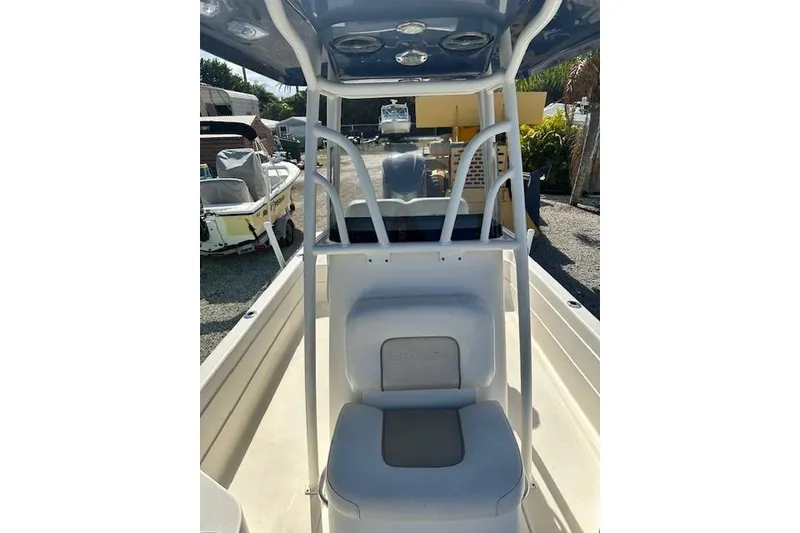 Slide: The Image of 2014 ShearWater 25 LTD boat interior with seating and console, parked outdoors. - 20