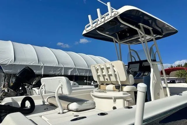 Slide: The Image of 2014 ShearWater 25 LTD boat with seating and canopy, docked under clear blue sky. - 6