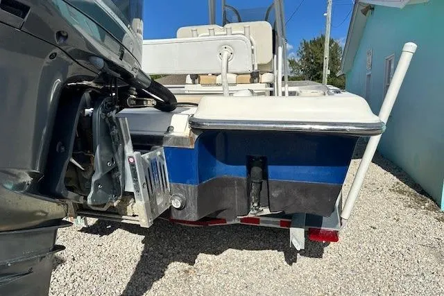 Slide: The Image of 2014 ShearWater 25 LTD boat rear view, showing motor and trailer on gravel. - 7