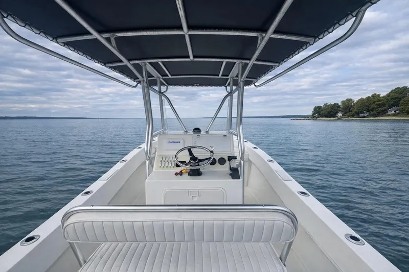 Slide: The Image of 2017 Dusky 252 boat on calm water, featuring a central console and canopy. - 5