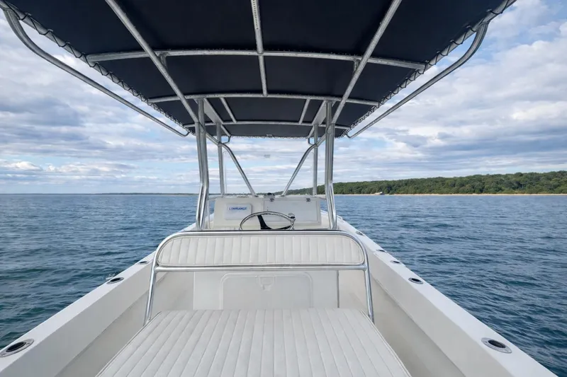 Slide: The Image of Dusky 252 boat, 2017 model, cruising on open water with scenic shoreline view. - 6