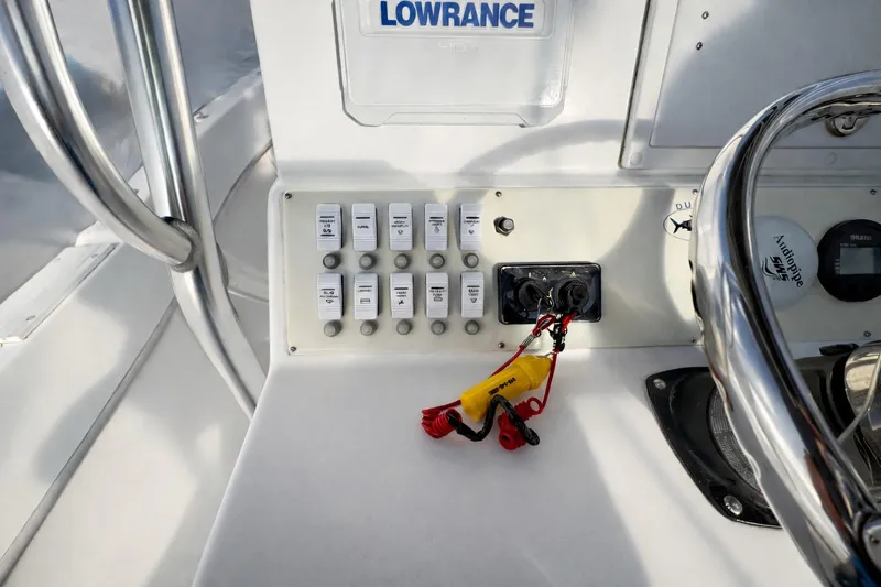 Slide: The Image of Control panel of a 2017 Dusky 252 boat with switches and steering wheel. - 8