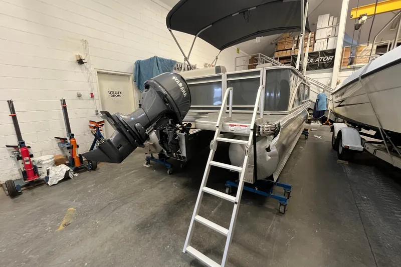 Slide: The Image of 2026 Godfrey Sweetwater 2086 CP pontoon boat in a workshop with Yamaha outboard motor. - 6