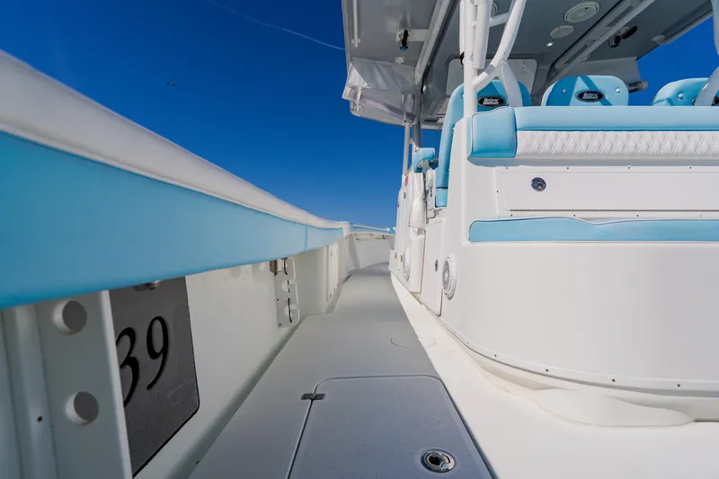 Slide: The Image of 2015 Yellowfin 39 Offshore boat interior with blue and white seating under clear sky. - 23
