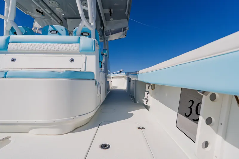 Slide: The Image of 2015 Yellowfin 39 Offshore boat interior with blue and white seating under clear sky. - 24