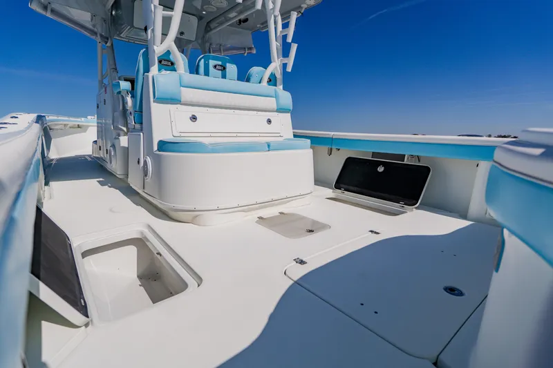 Slide: The Image of 2015 Yellowfin 39 Offshore boat interior with blue and white seating under clear sky. - 29