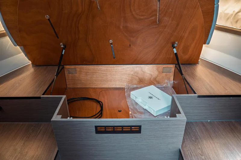 Slide: The Image of 2025 Jeanneau NC 895 Series 2 interior storage compartment with wooden finish and accessories. - 38