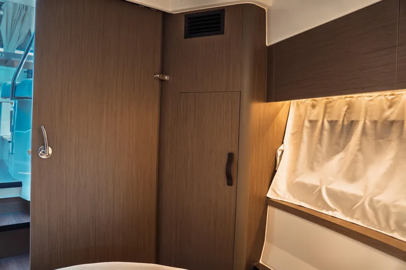 Slide: The Image of Interior of 2025 Jeanneau NC 895 Series 2, featuring wooden cabinetry and curtained window. - 40