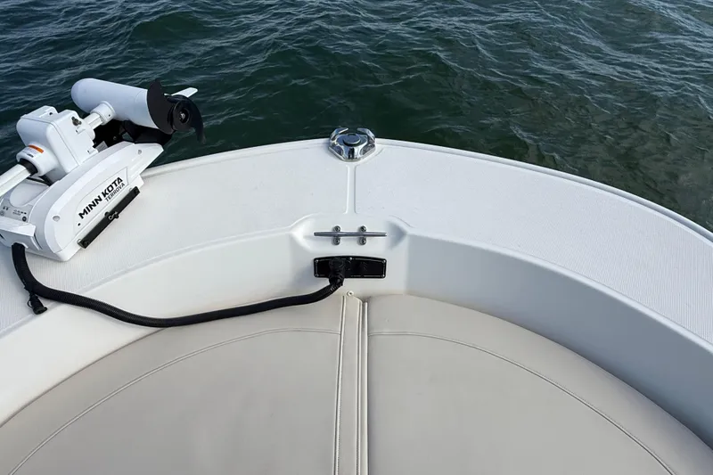 Slide: The Image of 2024 Boston Whaler 210 Montauk boat with Minn Kota trolling motor on calm water. - 12