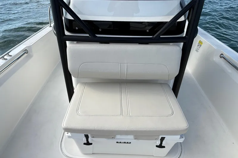 Slide: The Image of 2024 Boston Whaler 210 Montauk boat interior with cushioned seating and storage. - 14