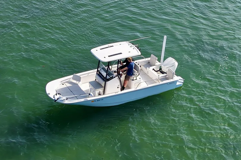 Slide: The Image of 2024 Boston Whaler 210 Montauk boat cruising on clear green water. - 2