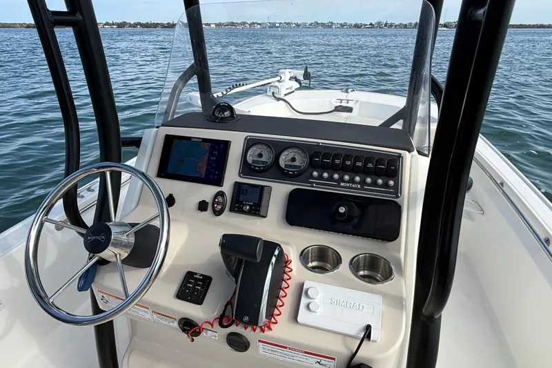 Slide: The Image of 2024 Boston Whaler 210 Montauk boat dashboard with steering wheel and navigation controls. - 23