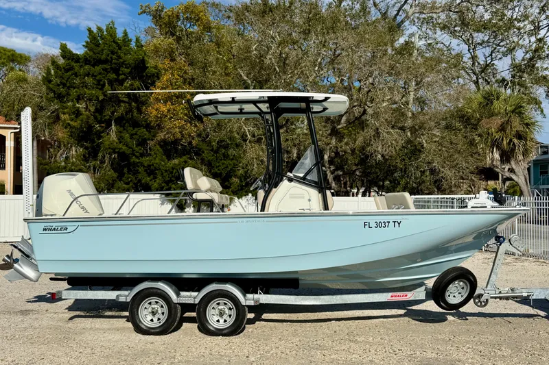 Slide: The Image of 2024 Boston Whaler 210 Montauk boat on trailer, parked outdoors. - 26