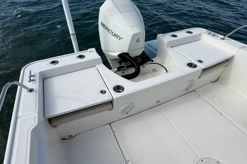 Slide: The Image of 2024 Boston Whaler 210 Montauk boat deck with Mercury engine, featuring storage compartments. - 7