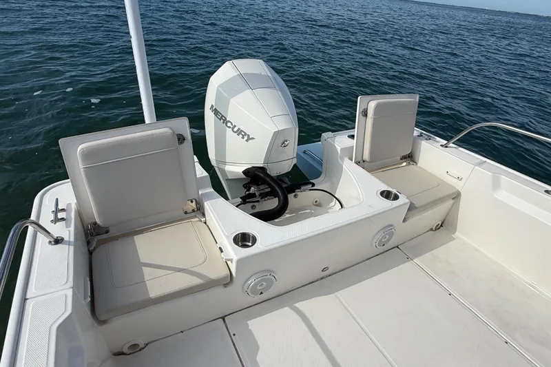 Slide: The Image of 2024 Boston Whaler 210 Montauk boat with Mercury engine on open water. - 8