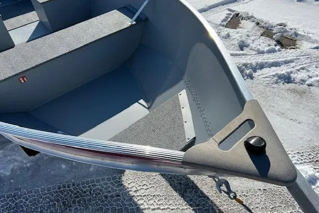 Slide: The Image of 2026 Lund SSV-16 boat on snowy ground, showcasing interior seating and bow design. - 15