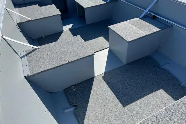 Slide: The Image of 2026 Lund SSV-16 boat interior with gray carpeted seating and storage compartments. - 17