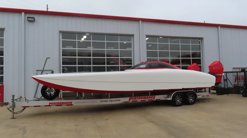 The Image of 2019 Doug Wright 32 powerboat on trailer outside a garage. - 0