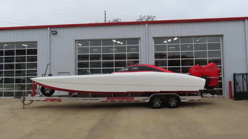 Slide: The Image of 2019 Doug Wright 32 powerboat on trailer outside a garage. - 2