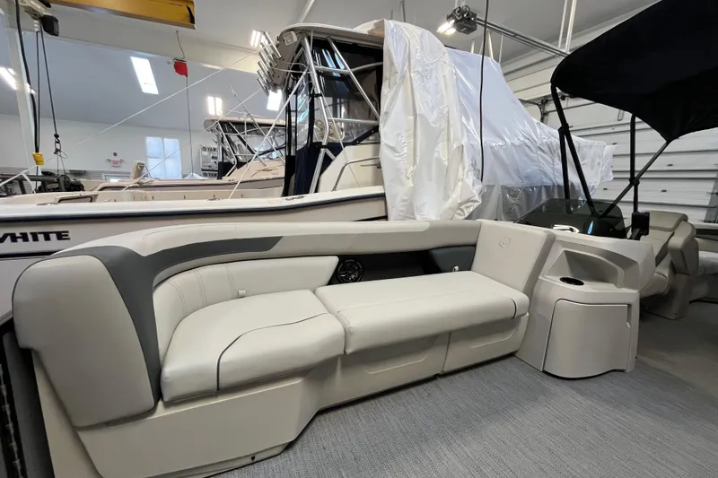 Slide: The Image of 2026 Godfrey Sweetwater 2286 MT pontoon boat interior with plush seating in a showroom. - 19