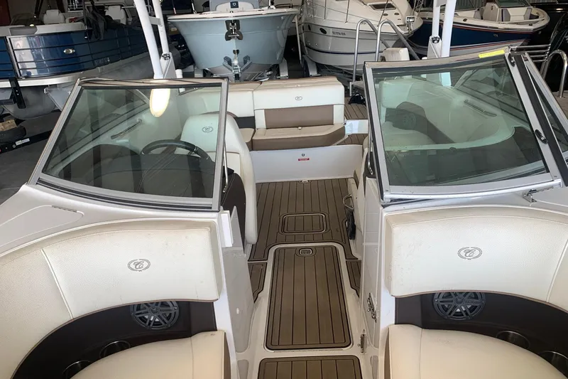 Slide: The Image of 2017 Cobalt 220S boat interior with beige seating and wood-style flooring. - 21