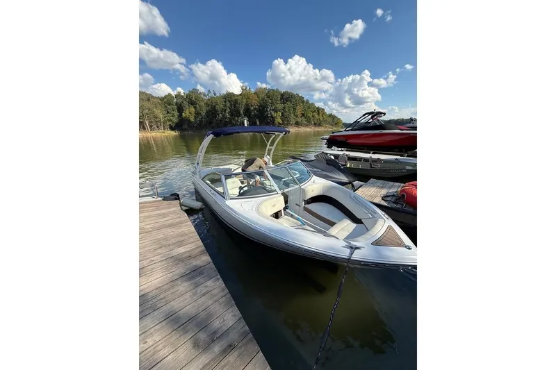 Slide: The Image of 2017 Cobalt 220S boat docked on a serene lake under a clear blue sky. - 3