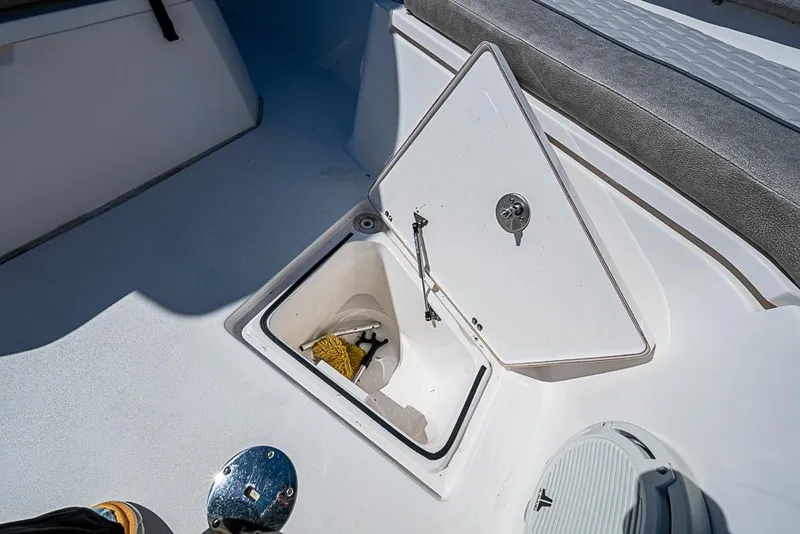 Slide: The Image of 2018 Sea Fox 328 Commander boat storage compartment with open hatch and cleaning supplies. - 13