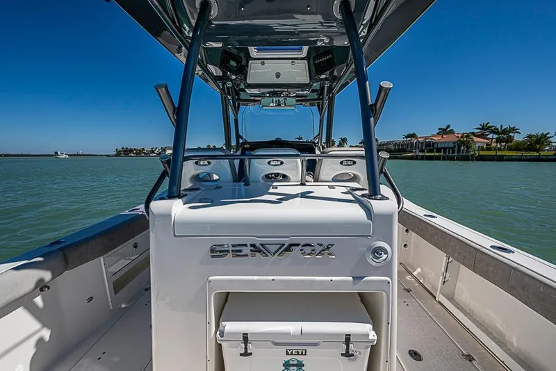 Slide: The Image of 2018 Sea Fox 328 Commander boat on water, clear sky, luxury waterfront homes. - 19