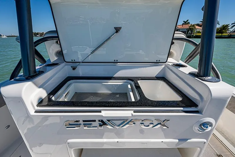 Slide: The Image of 2018 Sea Fox 328 Commander boat with open storage compartment, docked by the water. - 20