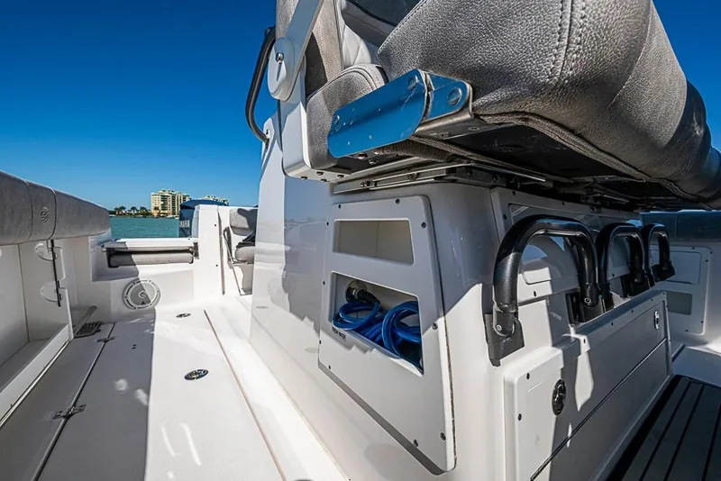 Slide: The Image of 2018 Sea Fox 328 Commander boat interior with seating and storage, under clear blue sky. - 30