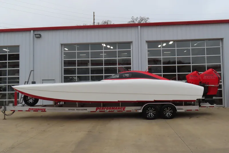 Slide: The Image of 2019 Wright Performance 320 Race boat on trailer, parked outside a garage. - 1