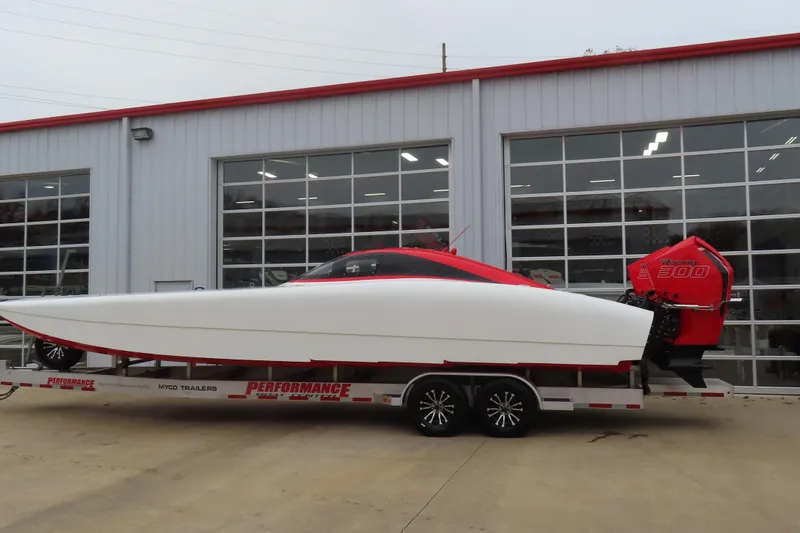 Slide: The Image of 2019 Wright Performance 320 Race boat on trailer, parked outside a garage. - 2