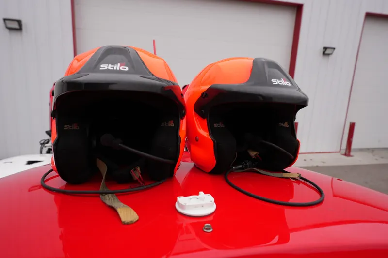 Slide: The Image of Two orange racing helmets on a red Wright Performance 320 Race car, 2019 model. - 32