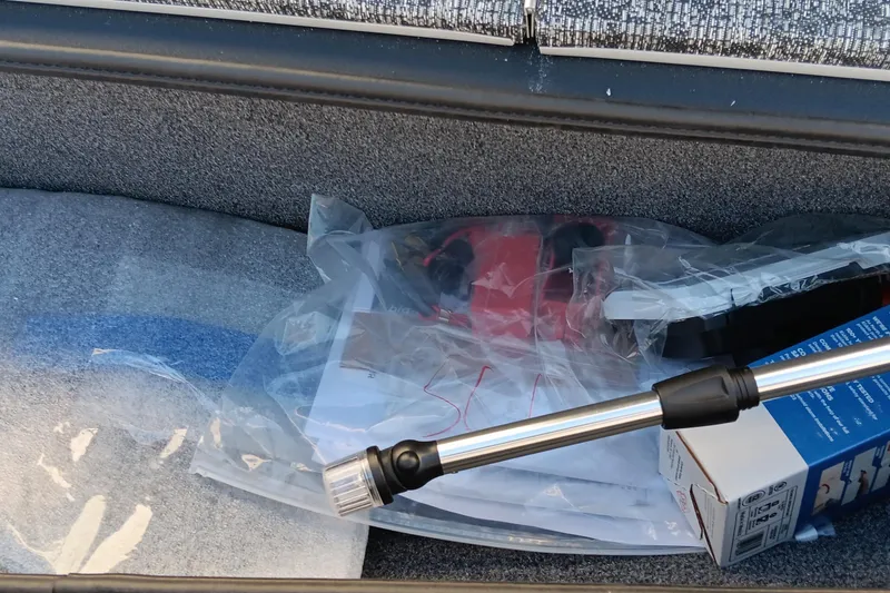 Slide: The Image of Storage compartment of 2026 Tracker Pro Team 175 boat with various items. - 11