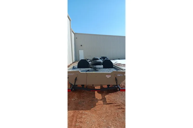 Slide: The Image of 2026 Tracker Pro Team 175 boat on trailer, parked near a building under clear blue sky. - 3