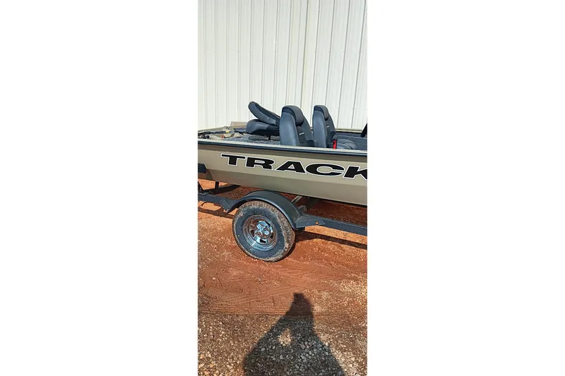 Slide: The Image of 2026 Tracker Pro Team 175 boat on trailer, side view, parked on gravel. - 8