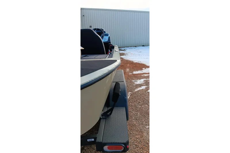 Slide: The Image of 2026 Tracker Savage 215 boat on trailer, parked on snowy gravel near a metal building. - 15