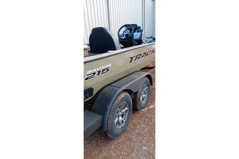 Slide: The Image of 2026 Tracker Savage 215 boat on trailer, side view with visible steering console. - 16