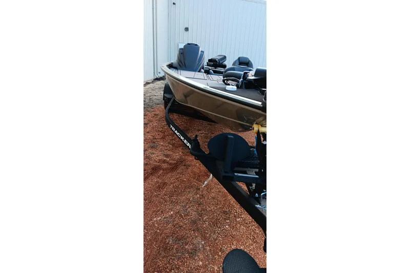 Slide: The Image of 2026 Tracker Savage 215 boat on trailer, parked on gravel near a building. - 4
