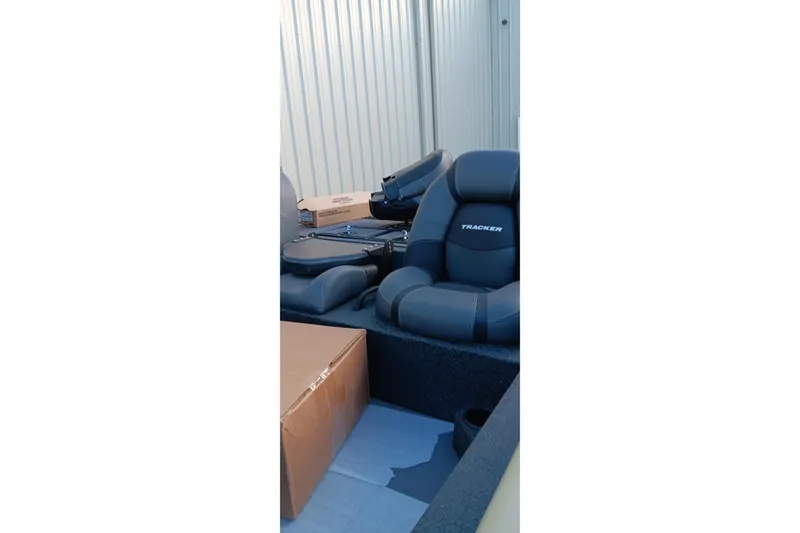 Slide: The Image of 2026 Tracker Savage 215 boat interior with cushioned seats and storage boxes. - 6