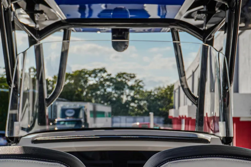 Slide: The Image of 2024 Renegade 38 Open boat interior view with clear windshield and outdoor background. - 17