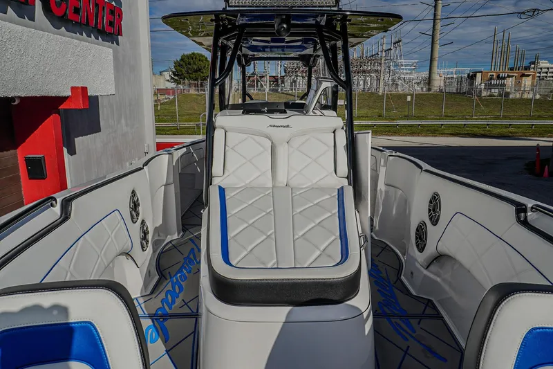 Slide: The Image of 2024 Renegade 38 Open boat interior with white and blue seating, docked near a center. - 28
