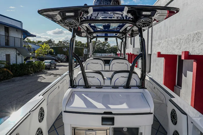 Slide: The Image of 2024 Renegade 38 Open boat interior with seating and speakers, docked outdoors. - 29