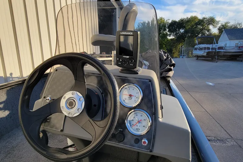 Slide: The Image of 2018 Bass Tracker Pro 16 boat dashboard with steering wheel and gauges. - 24