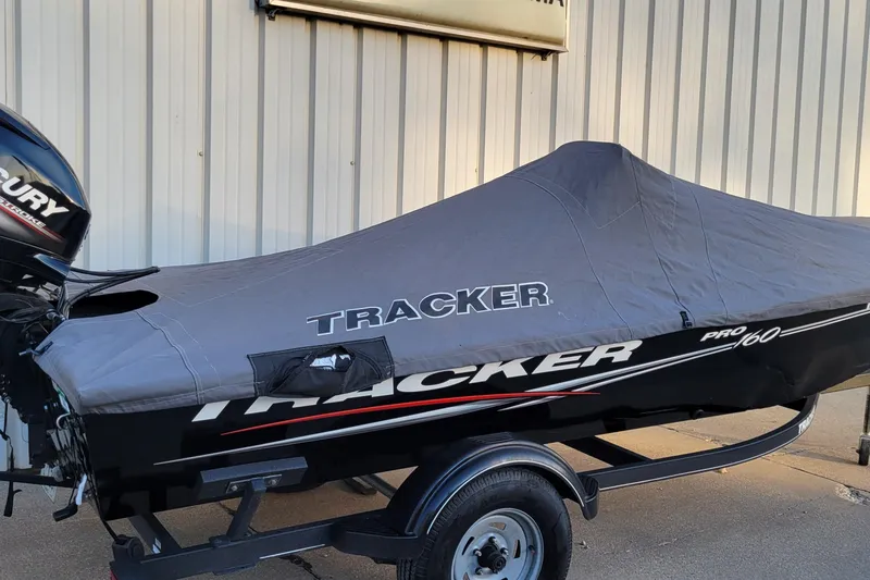 Slide: The Image of 2018 Bass Tracker Pro 16 boat with cover on trailer, parked outdoors. - 6