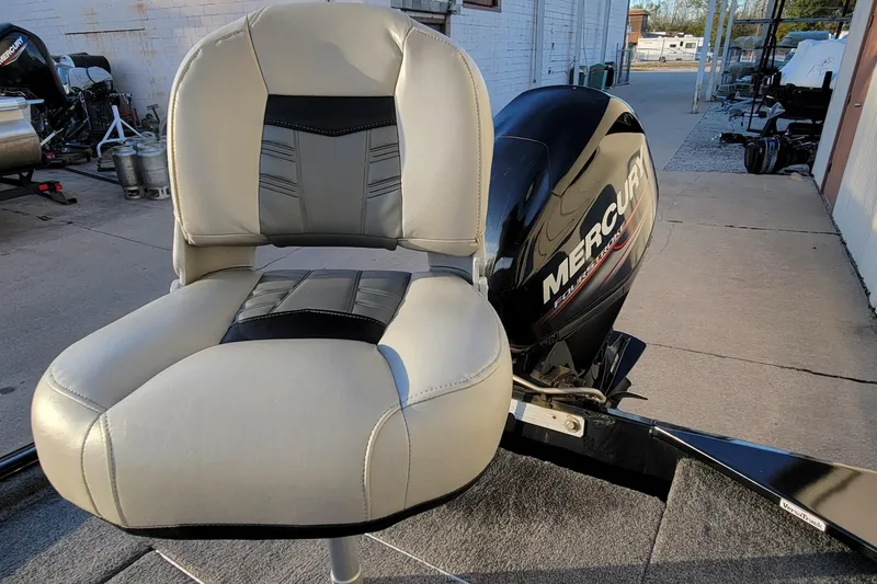 Slide: The Image of 2018 Bass Tracker Pro 16 boat seat and Mercury outboard motor in a marina setting. - 15