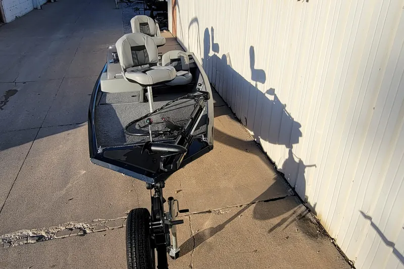 Slide: The Image of 2018 Bass Tracker Pro 16 boat parked on concrete near a white wall. - 26